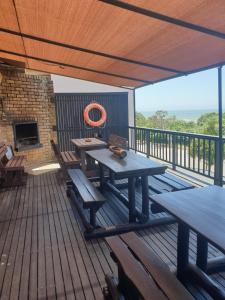 a deck with a picnic table and benches on it at Deep Blue Guest House in Amanzimtoti