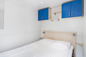 オーフスにあるFirst Camp Åhus-Kristianstadの青いキャビネットとベッドが備わる小さな客室です。