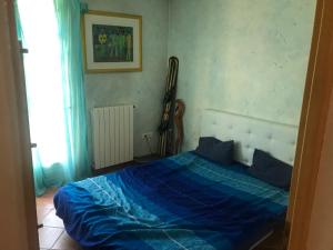 a bedroom with a blue bed with a guitar on the wall at Coeur de ville maison piscine in Saint-Raphaël