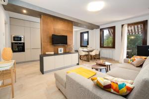 Riviera degli Ulivi - Terrace over the castle في توري ديل بيناكو: غرفة معيشة مع أريكة وتلفزيون ومطبخ