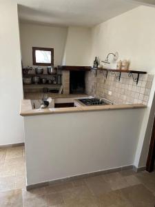 uma cozinha com um fogão e uma bancada em Casa Giuliveto - Charmantes Ferienhaus mit Privatpool in Olivenhain em Ostuni