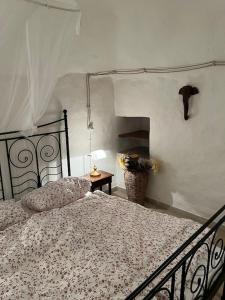 um quarto com uma cama e uma mesa com um candeeiro em Casa Giuliveto - Charmantes Ferienhaus mit Privatpool in Olivenhain em Ostuni