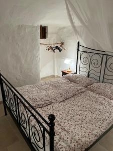 um quarto com uma cama preta e um edredão em Casa Giuliveto - Charmantes Ferienhaus mit Privatpool in Olivenhain em Ostuni