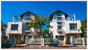 a white building with a fence in front of it at PSA Nghi Sơn Condotel in Thanh Hóa