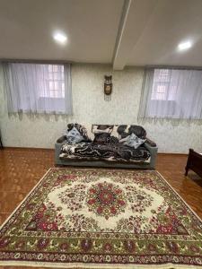 a couch in a living room with a rug at Gio Apartment in Tbilisi City