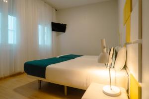 a bedroom with a bed and a lamp on a table at Smartr Madrid Chueca in Madrid