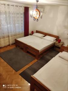a bedroom with two beds and a chandelier at House Bogović in Karlovac