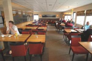 a dining room with people sitting at tables in a restaurant at Hamarøy Hotel in Innhavet