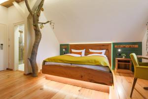 a bedroom with a bed and a tree in it at Landgasthof Hessenmühle in Großenlüder