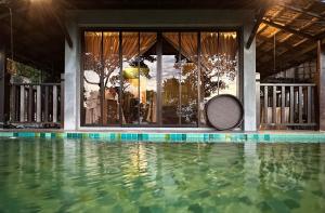 a swimming pool with a tennis racket sitting next to a house at Bao Sheng Durian Farm in Balik Pulau