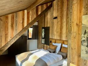 a bedroom with a large bed in a wooden wall at DualPark Afritz am See in Scherzboden