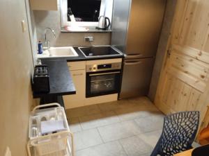 a small kitchen with a sink and a stove at #HANDWERKER_Rustikal Cityapartment Bielefeld Mitte in Bielefeld
