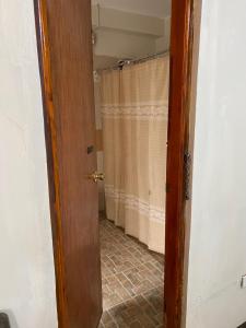 eine Tür zu einem Bad mit einem Duschvorhang in der Unterkunft Palanca Lodging Home in Candelaria