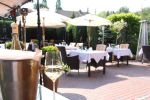 a glass of wine sitting on a table at a restaurant at Schäfers Hotel in Cloppenburg