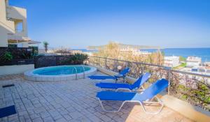 patio z niebieskimi krzesłami i basenem w obiekcie Blue Villas w mieście Agia Marina Nea Kydonias
