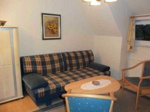 ein Wohnzimmer mit einem Sofa und einem Tisch in der Unterkunft Ferienwohnungen Am Schwanenteich in Rostock