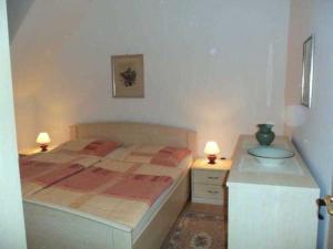 ein Schlafzimmer mit einem Bett und einem Schreibtisch mit zwei Lampen in der Unterkunft Ferienwohnungen Am Schwanenteich in Rostock