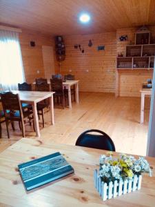 Habitación con mesas, sillas y suelo de madera. en Ushba Cottages, en Mazeri
