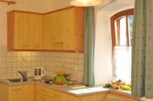 a kitchen with wooden cabinets and a sink and a window at Gosthof Kastelruth in Castelrotto