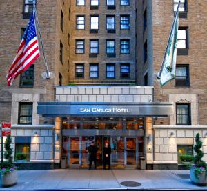 twee mensen staan bij de ingang van het San Francisco hotel bij San Carlos Hotel New York in New York