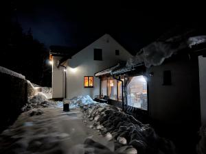 a building with snow on the side of it at night at Chata Klinger in Banská Štiavnica