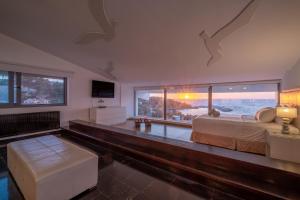 1 dormitorio con cama y vistas al océano en Icarus Luxury Beachfront Villa, en Gialiskari