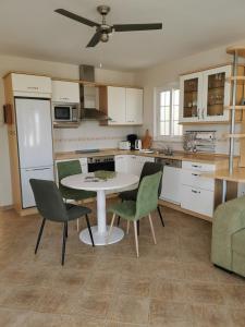 uma cozinha com uma mesa e cadeiras numa cozinha em La Casa Amarilla em La Pared