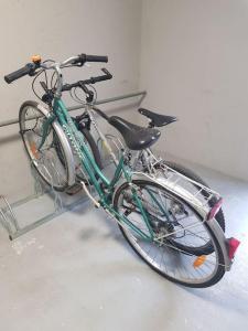 a green bike parked in a bike rack at Le studio 19 in Saint-Cast-le-Guildo