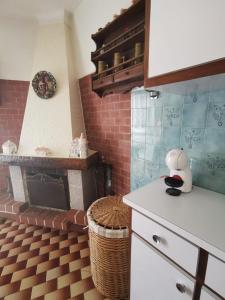 a kitchen with a brick fireplace and a counter top at O Mercadinho in Poiares