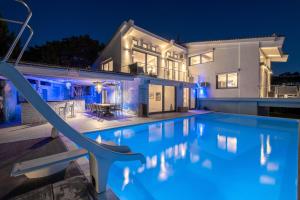 una casa con piscina por la noche en Icarus Luxury Beachfront Villa, en Gialiskari