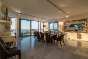 comedor con mesa, sillas y espejo en Icarus Luxury Beachfront Villa, en Gialiskari