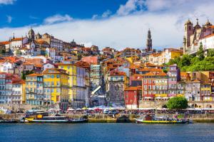 Oca Ribeira do Porto AT في بورتو: مدينة بها مباني وقوارب ملونة في الماء
