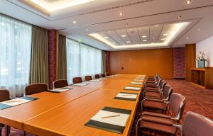 una gran sala de conferencias con una mesa larga y sillas en Parkhotel Görlitz en Görlitz