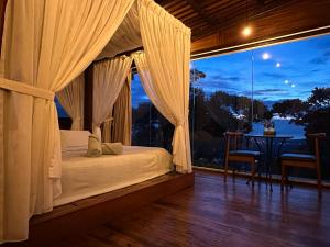 een slaapkamer met een bed en een groot raam bij Bao Sheng Durian Farm in Balik Pulau