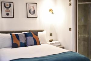 a bedroom with a bed and some pictures on the wall at Terrace House in Leamington Spa