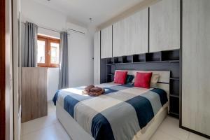 a bedroom with a large bed with red pillows at Idyllic Apartment just off the Promenade in Sliema