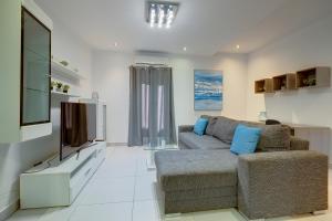a living room with a couch and a flat screen tv at Idyllic Apartment just off the Promenade in Sliema