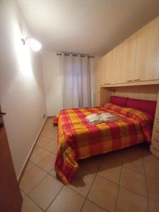 - une chambre avec un lit et une couverture colorée dans l'établissement Appartamento Stalle Lunghe, à Prato Nevoso