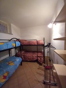 Zimmer mit 2 Etagenbetten und Fliesenboden in der Unterkunft Appartamento Stalle Lunghe in Prato Nevoso
