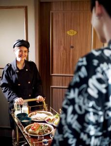 a woman standing in front of a table with food at Montraj Coach Sukhumvit Bangkok in Bangkok