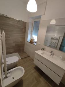 uma casa de banho com um lavatório, um WC e um espelho. em Patacchella House em Ostuni