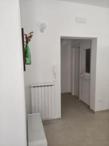 um quarto branco com um corredor com um vaso na parede em Patacchella House em Ostuni