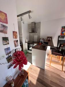 a kitchen and living room with a vase of flowers on a table at Appart 2 chambres 17 min de Paris in Rosny-sous-Bois