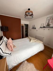 a bedroom with a large white bed in a room at Appart 2 chambres 17 min de Paris in Rosny-sous-Bois
