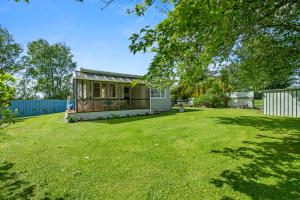 ein kleines Haus in einem Hof mit großem Rasen in der Unterkunft Carrington Countryside - New Plymouth Holiday Home in New Plymouth