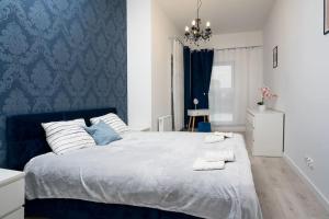 a bedroom with a large bed with blue wallpaper at Regal Park in Elblag