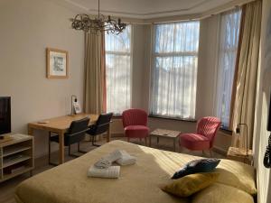 a bedroom with a bed and a table and chairs at Hotel Plato by Hofstad Studios in Scheveningen +94 photos