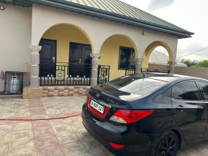 a car is parked in front of a house at BENJI'S VILLA in Kumasi