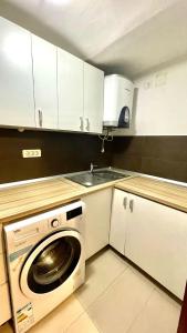 een keuken met een wasmachine en een wastafel bij Ultracentral Apartment in Arad