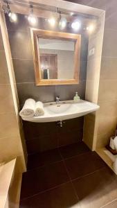 een badkamer met een wastafel en een spiegel bij Ultracentral Apartment in Arad